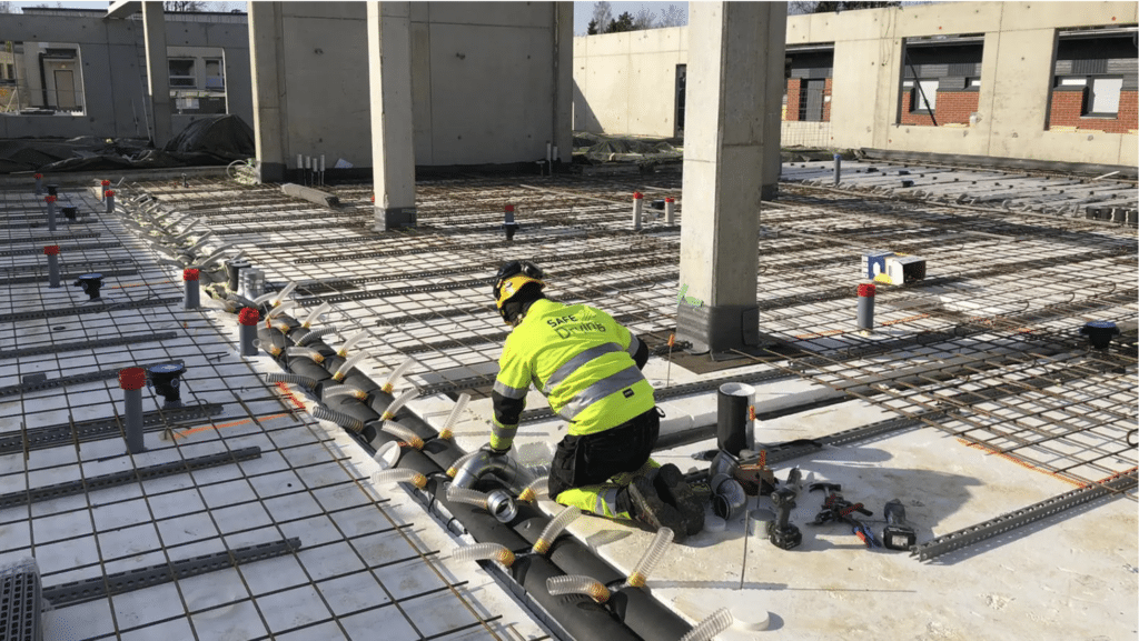 SafeDrying-menetelmä mahdollistaa alapohjan kuivattamisen myös lattiapinnoitteen asentamisen jälkeenkin. Kuvassa asennetaan parhaillaan kosteudenkeruukanavistoa.